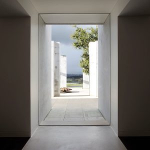 A long hallway featuring large windows that provide a view of the outside landscape