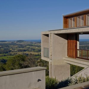 A modern concrete house with a wooden balcony